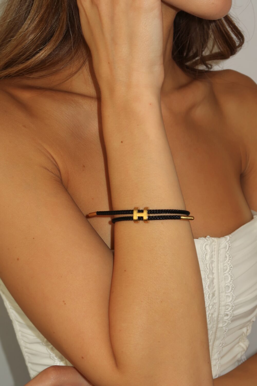 Pletena narukvica sa simbolom H – crvena/bela/crna